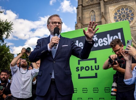 Petr Fiala talks into a mic during a street campaign outside a church