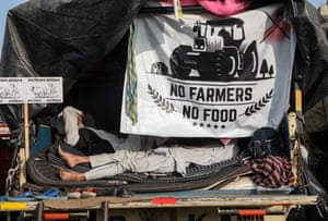 Farmers rest inside their truck during the protest at Singhu