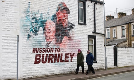 Burnley fans walk past a mural outside Turf Moor stadium.