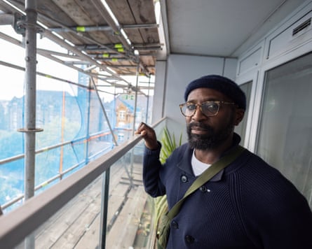 Dwayne Lewis stood on his balcony next to a load of scaffolding