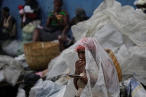A woman protects herself from rain brought by Hurricane Irma as she eats lunch in a street of Cap-Haitien, Haiti, September 7, 2017. REUTERS/Andres Martinez Casares