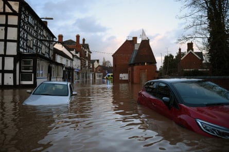 Flood water surrounds abandoned cars left in a flooded street