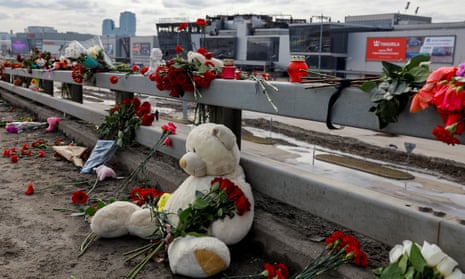 Flowers and toys are placed on the roadside in front of the burnt-out Crocus City Hall following a deadly attack on the concert venue on the outskirts of Moscow, Russia, March 26, 2024.