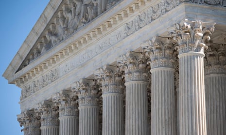 Detail shot of the US supreme court building, focusing on the 'Equal justice under law' motto carved at the top of the building's columns.