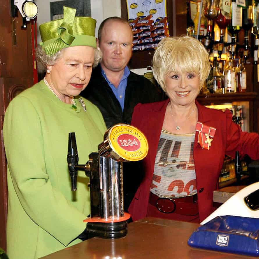 Queen Elizabeth II (left) in the Queen Vic pub during a visit to Elstree Studios where EastEnders is filmed.