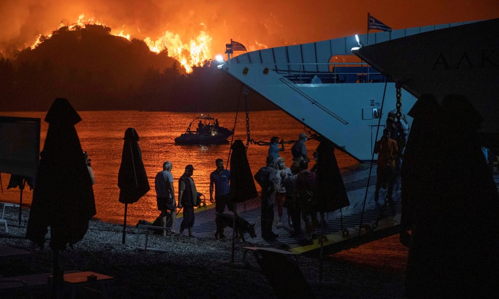People board ferry as fire rages on horizon
