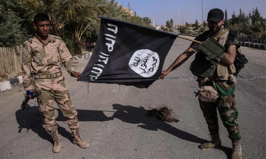 Syrian Arab Army soldiers hold a seized Islamic State flag in Palmyra, Syria, 2016.