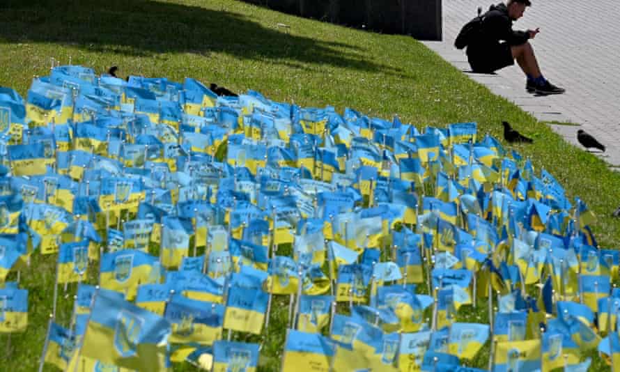 A grass plot decorated with small Ukrainian flags signed with the names of the Ukrainian servicemen killed in the war with Russia, in the centre of Kyiv.