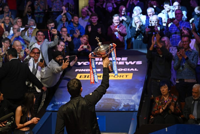 Ronnie O’Sullivan holds up the trophy after his victory over Judd Trump.