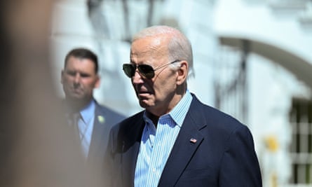 Biden in shades with out of focus White House in background
