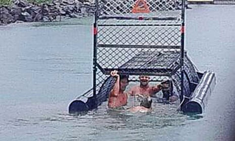 Facebook photo showing a group of men swimming into a baited crocodile trap near the site of a recent fatal attack.