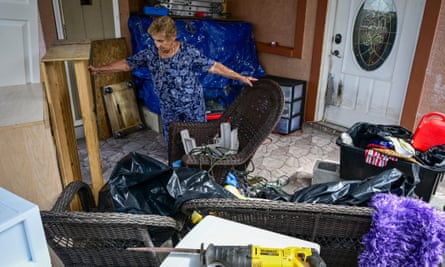 a woman tidies up after flooding in her home