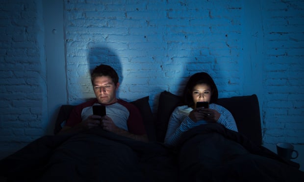 Young couple on their phones in bed