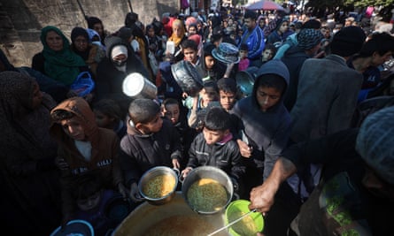 A huge crowd of displaced Palestinians queue for a hot meal in Deir al-Balah