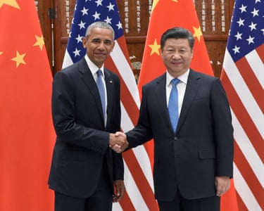 Chinese President Xi Jinping shakes hands with US President Barack Obama with US and Chinese flags behind them