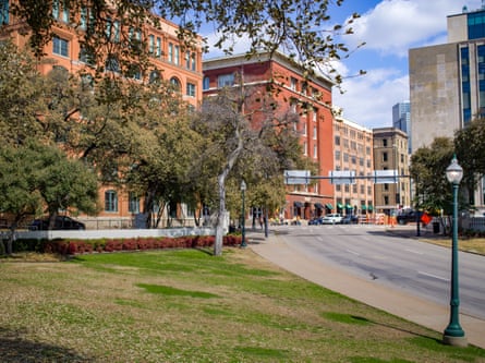 Dealey Plaza, with the fabled grassy knoll in the foreground and the book depository behind