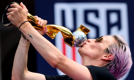 Megan Rapinoe, centre, lifts the Women’s World Cup alongside her US teammates at a parade in New York. The US have won the tournament four times. 