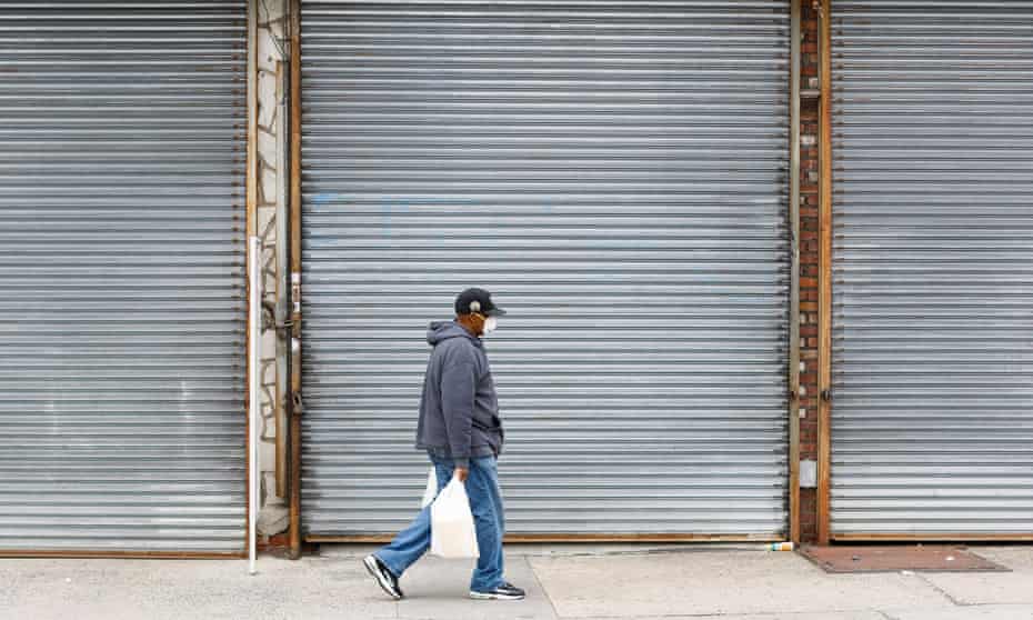 A man walks past shuttered businesses in the Bronx, New York, last week.