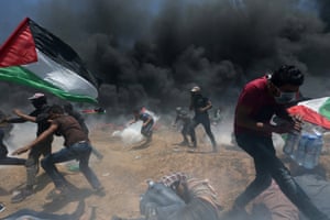 Palestinian demonstrators flee from Israeli fire and teargas