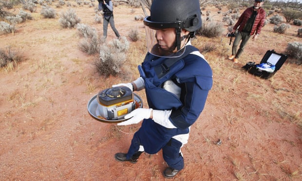 A member of Japan Aerospace Exploration Agency (JAXA) retrieves the first samples of asteroid subsurface, dropped by Hayabusa2 in Woomera