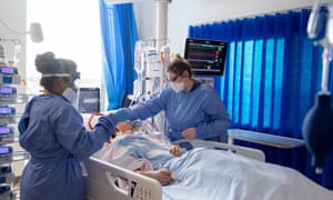 Slaugytojai rūpinasi Covid-19 sergančiais pacientais kritinės priežiūros skyriuje Karališkojoje Papworth ligoninėje, Kembridže, JK.