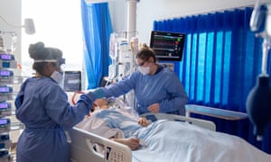 Slaugytojai rūpinasi Covid-19 sergančiais pacientais kritinės priežiūros skyriuje Karališkojoje Papworth ligoninėje, Kembridže, JK.