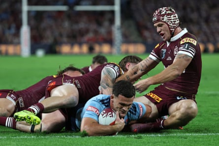 Nathan Cleary scores a effort while being tackled by Kalyn Ponga