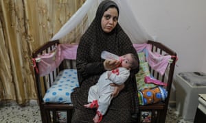 Hiba Swailam, 24, carrying her five-month-old baby in Beit Lahia.