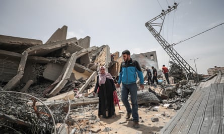Palestinians search their usable wares from collapsed buildings after Israeli warplanes carried out airstrikes in Gaza City, Gaza on May 06, 2019