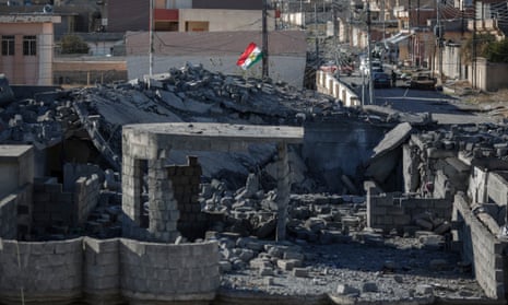The flag of the Kurdish regional government flies above a house that has been bombed in Sinjar, Iraq.