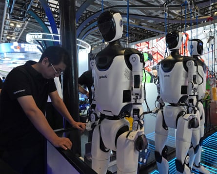 A worker on a line producing humanoid robots