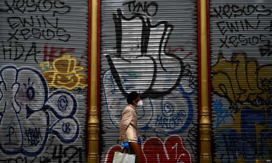 A woman walks past shuttered shops in Madrid.
