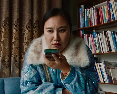 Teacher Wang holding up her phone in Mistress Dispeller