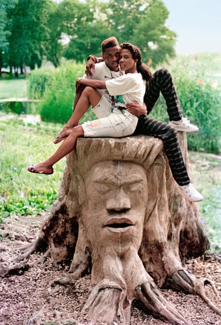 a man and a woman embracing each other on a carved tree stump