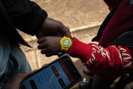 A student waits to be tapped so he can pick food.
