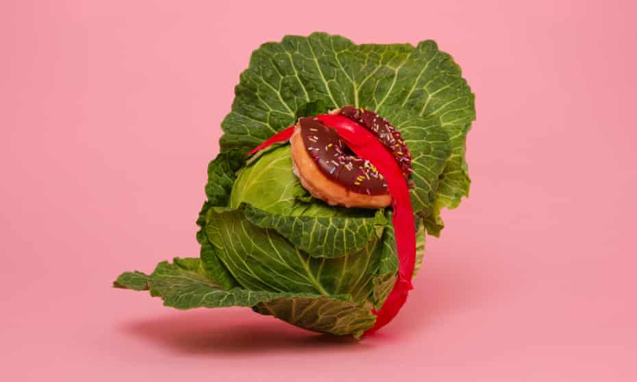 A cabbage with a doughnut taped to it