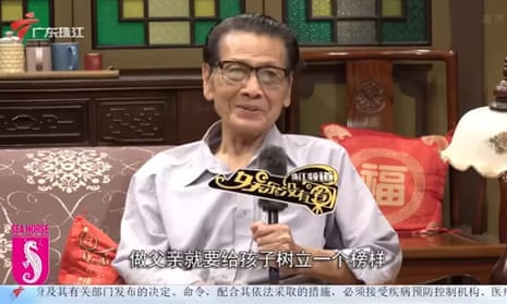 Actor Gong Jintang holding a microphone while seated on a couch