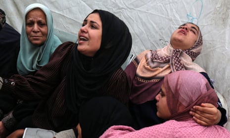 Mourners react next to the bodies of Palestinians killed at Maghazi refugee camp