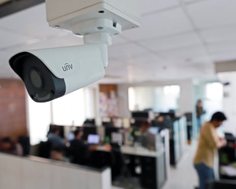 A facial recognition security camera mounted on a ceiling, with a blurred office behind