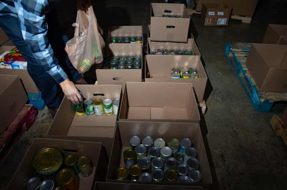 Pplacing canned food into cardboard boxes.