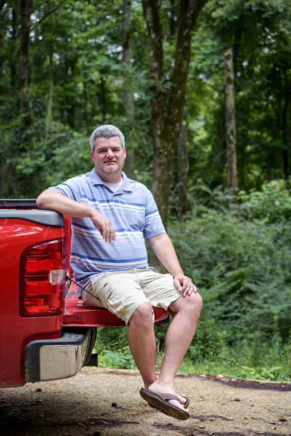 Kevin Davis sidder på bagklappen på sin lastbil i Simpson County, Mississippi.Kevin Davis sidder på bagklappen på sin lastbil i Simpson County, Mississippi. Fotografi: Kate medley/The Guardian