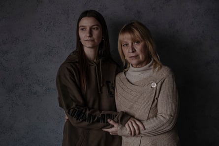 Yaryna and Viktoria Herashchenko stand side by side holding each other