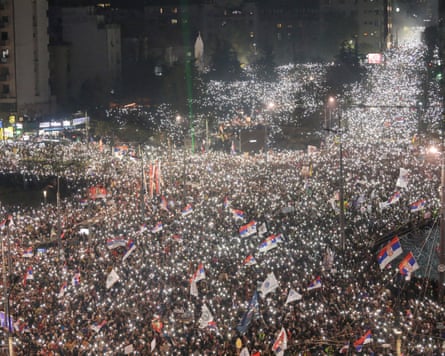 Thousands of people waving flags light up the meeting of thoroughfares with their mobile phone torches