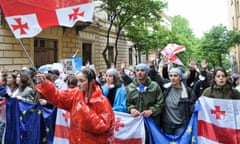 Protestesters wave flags as they pass the parliament building in Tbilisi on Tuesday.