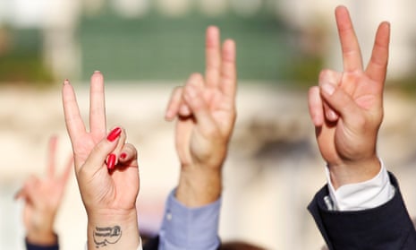 People show a peace sign at the funeral ceremony of journalist Daphne Caruana Galizia.