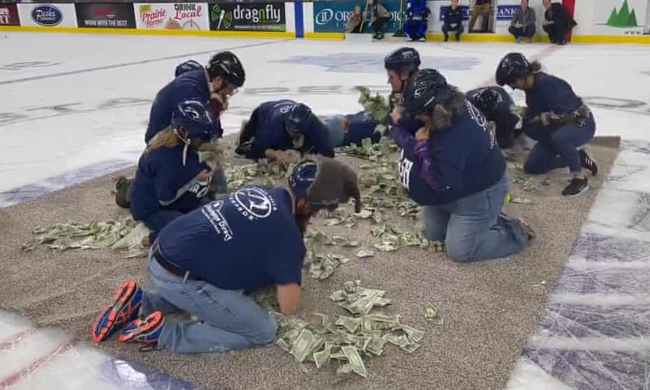 South Dakota teachers scramble for cash during half-time show.