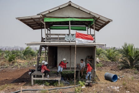 Members of the Power of Mama team educate local residents at agricultural land while patrolling in Sungai Putri village