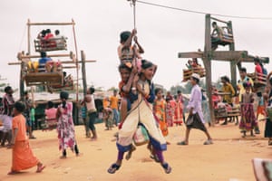 Rohingya children ride on human-powered ferris wheels in the Kutupalong camp.