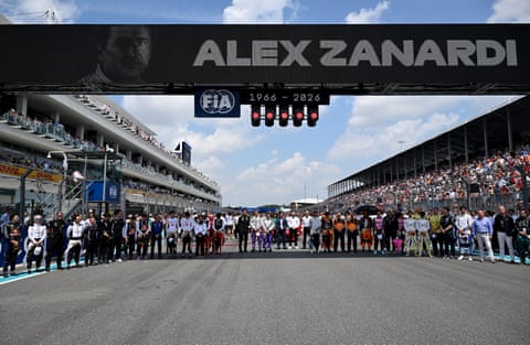 Pilotët dhe personeli i ekipit qëndrojnë në pistën e pistës në nder të të ndjerit Alex Zanardi para garës së sprintit F1 në Autodromin Ndërkombëtar të Miamit.