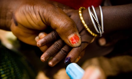 A community volunteer marks the finger of a child with ink during a polio immunisation exercise.